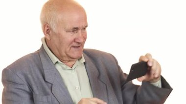 Zeki telefonuyla selfie çekerken gümüş saçlı neşeli bir son sınıf öğrencisi modern teknolojinin neşesini sergiliyor. Onun anlamlı gülümsemesi mutluluk saçıyor, bağlantı ve eğlenceyle dolu canlı bir yaşam tarzını yansıtıyor.
