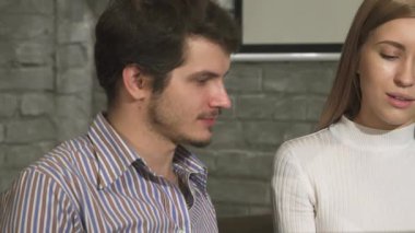 Modern bir ofis ortamında erkek arkadaşıyla canlı bir tartışmaya girerken, kendine güveni tam, genç ve güzel bir iş kadını yaklaştı. Etkileşimleri pozitiflik ve yaratıcılıkla dolu.