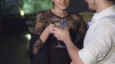 Sevimli genç bir çift zarif bir barda kadeh kaldırıyor. Aşklarını kutlarken neşe ve bağ yayıyorlar. Göz kamaştırıcı siyah dantelli bir elbise giyen kadın ve partneri, beyaz bir gömlek içinde büyüleyici bir sahne yaratıyor.