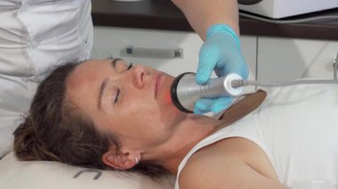 Olgun bir kadın, yetenekli bir kozmetik uzmanı olarak doğal güzelliğini geliştirmek için canlandırıcı bir yüz bakımı uygular. Güzellik salonunun rahatlatıcı atmosferi, gelişmiş teknolojiyle birleşince, etkili bir cilt sıkılaştırma vaat ediyor.