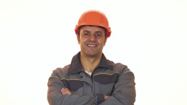Parlak turuncu şapkalı neşeli, olgun bir İspanyol yapıcı gururla ışıldıyor ve iki hevesli baş parmağını kaldırıyor. Kendine güvenen gülüşü olumlu ve başarılı, inşaat endüstrisinin ruhunu somutlaştıran ve kendini işine adamış biri.