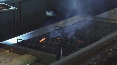 Dinamik bir yakın plan, canlı bir restoranın mutfağında leziz domuz bifteği pişiren yetenekli bir aşçıyı yakalıyor. Cızırdayan et ve dans eden ateş kışkırtıcı bir atmosfer yaratıyor, mutfak işçiliğinin sanatını ve...