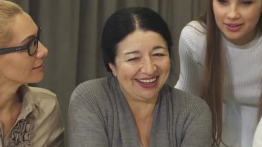 Canlı bir yakın plan, neşeli, olgun iş kadınlarını ve genç meslektaşlarını canlı sohbetler yaparak pozitiflik ve güven yayarak yakalıyor. Gülüşleri ve kahkahaları, takım çalışmasının gücünü gösteren davetkar bir atmosfer yaratıyor.