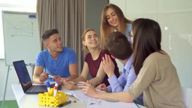 Yaratıcı genç profesyonellerden oluşan canlı bir grup şık bir ofis masasında dizüstü bilgisayarın etrafında ateşli bir tartışmaya girişiyor. Sahnede, iki yakışıklı erkek ve iki de erkek olmak üzere, oturan meslektaşlarının arkasında duran neşeli, beyaz bir kız yer alıyor.
