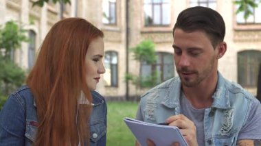 Neşeli bir Kafkasyalı kampüste otururken egzersiz defterine tutkuyla resim çiziyor. Muhteşem kızıl saçlı sınıf arkadaşı neşe saçarak bir bankta poz veriyor. Canlı bir üniversite ortamında neşe ve dostluk saçıyor.