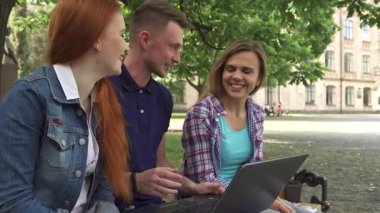 Üç neşeli Kafkasyalı öğrenci, yakışıklı sarışın bir adam ve iki güzel kız, verimli bir kampüs parkında güneşli bir bankta otururken dizüstü bilgisayarlarında iş birliği yapıyorlar. Gülüşleri ve hareketleriyle, canlı bir dostluk ve takım çalışması atmosferi yansıtıyorlar.
