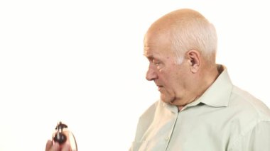 Gri saçlı yaşlı bir adam alarm saatini kontrol ederken şok olmuş görünüyor. Yüzünde endişe ve aciliyet ifadesi var. Sahne, zaman yönetiminin mücadelesinin özünü yakalıyor, teslim tarihlerinin duygusal ağırlığını ve stresi gösteriyor.