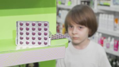 Neşeli gülüşü olan meraklı küçük bir çocuk parlak bir eczanede renkli haplar paketini inceliyor. Sağlık ürünleriyle uğraşırken çocukluğun masumiyetini yakalıyor. Keşif ve refah dolu bir dünyayı gözler önüne seriyor.