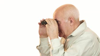 Neşeli bir büyükbaba, sıcak bir gülümsemeyle, dürbünle dünyayı keşfettikten sonra kameraya bakar. Onun parlak ifadesi neşe ve merak saçıyor, macera ruhunu ve emeklilikteki rahatlığı somutlaştırıyor.