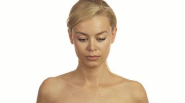 Çarpıcı yeşil gözleri ve kusursuz derisi olan genç bir kadın başlangıçta aşağıya bakar, sonra kameraların merceğine bakmak için kafasını kaldırır, neşeyle parlar. Uzun, parlak sarı saçları, saf beyaz arka plana karşı yüzünü güzelce çerçeveliyor.