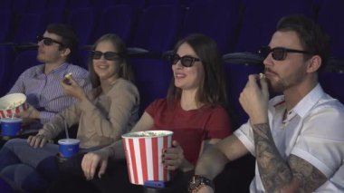 Üç boyutlu şık gözlük takan iki mutlu çift, canlı bir sinema ortamında kahkaha ve patlamış mısır paylaşıyorlar. Animasyon ifadeleri ve rahat duruşları eğlenceli bir gece için mükemmel, canlı bir atmosfer yaratıyor.