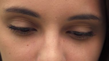 Çekici esmer bir kız gözlerini kocaman açar, büyüleyici bir bakışla seni kendine çeker. Bu yakın plan, onun kusursuz cildinin ve zarif makyajının güzelliğini yakalıyor, uzun kirpiklerini ve neşeli ifadesini vurguluyor.