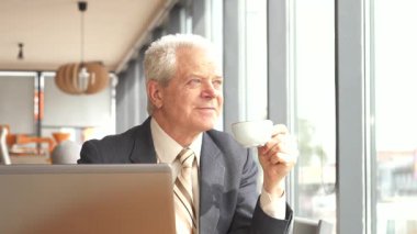 Seçkin bir üst düzey Kafkas işadamı şık bir kafe masasında oturur, kahve yudumlarken dikkatlice pencereden dışarı bakar. Sivri bir takım elbise ve kravat giyip, bir anlık düşünmeyi sever. Yanında dizüstü bilgisayarı da açıktır.