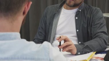 Olgun bir iş adamını ciddi bir ifadeyle yakına çeken yakın çekim, önemli bir iş görüşmesi sırasında iş arkadaşını dinlerken derinden bağlanıyor. Atmosfer profesyonellik ve odaklanma ile dolu.