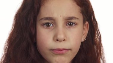 Büyüleyici bir yakın planda kıvırcık saçlı küçük bir kız parmağını dudaklarına götürür ve sessizlik için işaret eder. Onun el değmemiş beyaz bir arka plana karşı olan ciddi ifadesi bir entrika ekliyor, izleyicileri sırrını paylaşmaya davet ediyor.