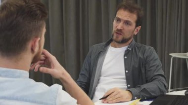 Olgun, sakallı bir iş adamı genç meslektaşı ile modern bir yönetim kurulunda ateşli bir tartışmaya girer. Atmosfer yaratıcılık ve işbirliği ile yükleniyor. Fikir ve stratejiler alışverişinde bulunuyorlar.