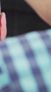 Bu canlı sahnede, bir berber bir kırpıcıyı ustalıkla manevra ettirir, erkek müşterisinin saç kesimini titizlikle şekillendirir. Berberin çarpıcı damalı gömleği zarif, modern berber dükkanının arka planına vurgu yaparak sanatın önemini vurguluyor.