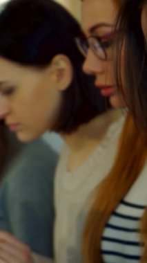 Canlı bir kız öğrenci kameraya doğru büyüleyici bir gülümseme sergiliyor, esmer saçı hareketli bir konferans salonunda zarif bir şekilde kıvrılıyor. Bu yakın plan güzel bir şekilde onun gençlik coşkusunu ve akademik ruhunu yakalıyor.