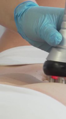 Kendini işine adamış bir güzellik uzmanı, kadın bir müşterinin midesine RF kaldırma cihazı uygular ve dingin güzellik salonunu sıcak bir ışıltıyla aydınlatır. Bu yenilikçi tedavi cilt sıkılaştırma ve gençleştirme vaad ediyor.