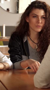 Şık bir şehir kafesinde, iki şık kız arkadaşlarının sözleriyle büyülenir, arkadaşlığın özünü sergilerler. Güzel Asyalı kadın kahvesini yudumlarken kıvırcık saçlı beyaz kız eğilip sıcak ve davetkar bir atmosfer yaratıyor.