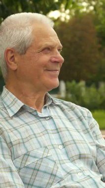 Güneşli bir parkta, küçük sevimli bir çocuk neşeyle büyükbabasının gözlerini kapar, neşeli bir sürpriz ve kahkaha patlatır. Işıl ışıl gülümseyen beyaz çocuk, kıdemli dedesinin arkasında duruyor.