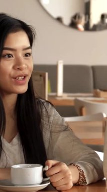 Modern dekorlarla dolu şık bir kafede, üç hayat dolu bayan arkadaş kahkahalarla kahkahaları paylaşıyor ve kahkahalar atıyorlar. Kıvırcık saçlı güzel Afrikalı Amerikalı kadın bir hikayeyi canlandırırken özenli Asyalı ve...