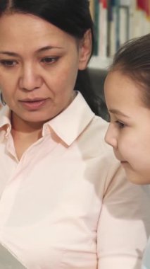 Keyifli bir Asyalı anne ve sevimli küçük kızı rahat bir kütüphanede kitap dünyasına dalmış, hayal güçlerini harekete geçiriyorlar. Ortak coşkuları ve merakları iç açıcı bir bağ ve keşif tablosu oluşturuyor.