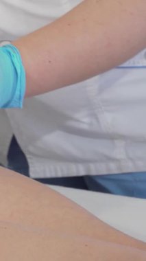 Büyüleyici yakın çekim gösterileri yetenekli güzellik uzmanları, bir kadının kalçasına masaj yaparak, selüloit azaltma için yenilikçi tekniği vurguluyor. Güzellik salonunun sakin havası artar.