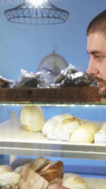 Sıcak bir fırında, olgun bir Asyalı kadın fırıncının yakışıklı erkek müşterisine sıcak bir somun zanaatkar ekmeği uzatarak sıcaklık ve bağlantı sağlaması gibi büyüleyici bir an yaşanıyor. Bir dizi taze pişmiş malla süslenmiş davetkar atmosfer.