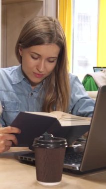 Canlı bir çalışma alanında, uzun kahverengi saçlı çekici genç bir kadın özenli erkek arkadaşıyla kitap hakkında görüşlerini paylaşıyor ve yaratıcılıkla dolu bir atmosfer yaratıyor. Modern çalışma alanı parlak sarı masalar içerir.