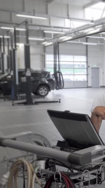 Odaklanmış bir tamirci ve onun çalışkan asistanı, hareketli bir araba tamir istasyonuyla çevrili, parlak bir dizüstü bilgisayarın teşhisi ile uğraşıyorlar. İşbirlikleri uzmanlık ve adanmışlık gösteriyor, her aracın yol olmasını sağlıyorlar.