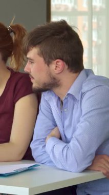 Neşeli bir Kafkas kızı dikkatle defterine yazarken tartışmanın derinliklerinde nişanlı meslektaşlarıyla çevrili. Modern ofis, parlak doğal ışıkla yıkanmış, yaratıcı ve takım çalışmasının canlı bir atmosferini teşvik ediyor, fikirlerin