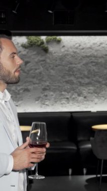 Hafif takım elbiseli şık bir genç adam kadehini kaldırıp kutlama ruhunu somutlaştırırken ışıl ışıl bir gülümseme sergiliyor. Şık bir bar atmosferiyle çevrelenmiş bu sahne karmaşıklık ve canlı bir gece hayatı ortamı yayar.