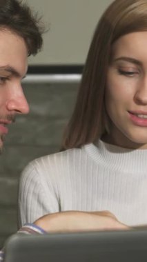 Yakışıklı genç bir iş adamı ve güzel bayan meslektaşı renkli belgeler, odaklanmış ifadeleri ve yaratıcılık ve takım çalışması üzerine bir animasyon tartışmasına giriştiler. Çağdaş tasarımı ve sıcaklığıyla gösterişli ofis ortamını.