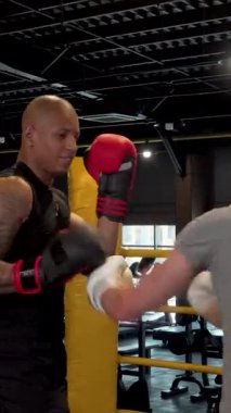 Dinamik bir boks salonunda, iki kararlı erkek boksör, atletik hünerlerini ve şiddetli rekabetlerini sergileyerek heyecan verici bir dövüş seansına girişir. Kırmızı eldivenli Afrikalı erkek boksör olağanüstü çeviklik ve güç sergiliyor.