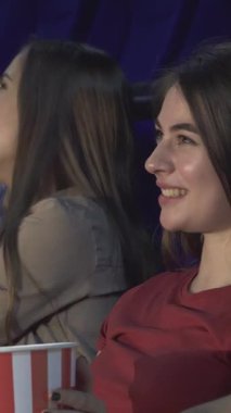 Canlı bir sinemada, iki çift yan yana oturur, büyüleyici film deneyimine tamamen dalmışlardır. Kırmızı tişörtlü kız neşeyle parıldıyor, gülüşü odayı aydınlatıyor patlamış mısırla şımartıyorlar ve birlikte unutulmaz anılar yaratıyorlar.