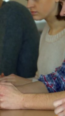 Aralarında hoş bir süveter giyen düşünceli bir kadın ve sakallı bir adamın da bulunduğu bir grup nişanlı öğrenci, güneşli bir konferans salonunda notlar alıyorlar. Atmosfer konsantrasyonla elektriklidir, kendilerini öğrenmeye adamışlardır.