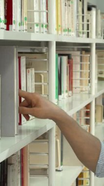 Şık sakallı, neşeli, genç bir esmer adam elinde akıllı bir telefonla bir kitap arıyor. Renkli, düzenli kitaplıkların arasında. Işıl ışıl gülüşü ve odaklanmış ifadesi bilgiye ve heyecana karşı derin bir tutkuyu yansıtıyor.