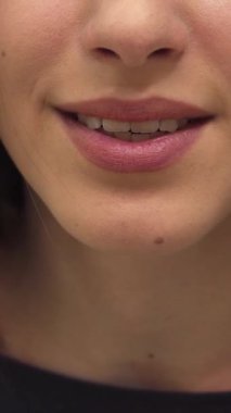 Zevkli, beyaz bir kadın şakacı bir şekilde hava öpücüğünü üflüyor, dudakları neşe saçan flörtöz bir jestle hafifçe yarılıyor. Yakın plan, büyüleyici gülümsemesini ve mükemmel manikürlü elini yakalar. Yeni makyajını ve parıldayan derisini gösterir.