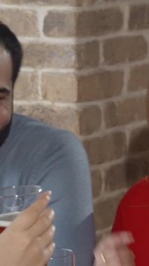 Arkadaşlar kırsal bir bira barında hareketli sohbetler yaparken, kahkahaları tuğla duvarların sıcacık ışıltısıyla uyumlu hale geliyor. Kadehlerimizi kaldırarak arkadaşlığımızı kutlarken atmosfer neşeyle uğulduyor.