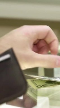 Şık, beyaz bir müşteri lüks bir iş yapıyor zarif bir cüzdandan zarif bir şekilde zarif bir butikte sofistike bir kadın satıcıya para dağıtıyor. Şık siyah eldivenlerle süslenmiş satıcı göz kamaştırıcı bir mücevher sunar.