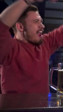 Coşkulu iki beyaz adam, mutluluk saçıyor, tezgahta sarılıyorlar, buzlu bira bardaklarını şen şakrak kaldırıyorlar. Bulaşıcı kahkahaları ve enerjik enerjileri havayı doldurarak havanın özünü yansıtan neşeli bir atmosfer yaratıyor.