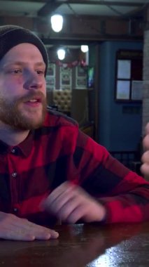 Canlı ve kareli gömlekli çekici sakallı bir adam barda oturmuş soğuk birasının tadını çıkarırken heyecanlı bir spor maçı izliyor. Bu genç Kafkas hayranı coşku ve dostluk saçıyor. Canlı ve canlı olanları mükemmel bir şekilde yakalıyor.