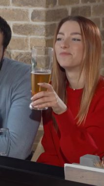 Canlı bir arkadaş grubu, sıcak bir barda bira bardaklarıyla neşeli bir şekilde kadeh kaldırıyor. Kırsal tuğla duvarlara karşı kahkahalar atıyorlar. Ortam ışıklarının sıcacık parıltısı şenlik ruhunu artırır, dostluk anları ve saf mutluluğu yakalar.