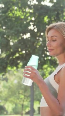 Işıl ışıl bir kadın neşe içinde su şişesinden yudumluyor, canlı bir parkın yemyeşil sularını süzen ılık güneş ışığını içine çekiyor. Bu canlı sahne sağlık ve canlılığı simgeliyor. Işıldayan gülümsemesini ve canlandırıcı atmosferini gösteriyor.