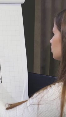 Canlı bir ofis ortamında, iki yetenekli iş kadını tutkuyla işbirliği yaparak beyaz tahtaya karmaşık grafikler çiziyor. Odaklanmış ifadeleri ve dinamik jestleri sinerji ve yaratıcılığı yayarak güçlü bir ortaklık sergiliyor.