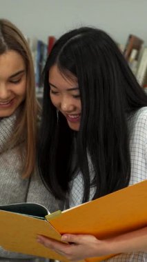 Parlak ve davetkar bir kütüphanede, biri dalgalı esmer saçlı, diğeri parlak siyah bukleli iki hevesli kız öğrenci, renkli defterlerinden bakış açılarını hevesle paylaşıyorlar. Etrafı kitaplarla dolu yüksek raflarla çevrili.