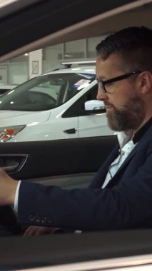 Özel dikim takım elbiseli dengeli bir satış müdürü modern bir arabada rahat bir şekilde oturan, gözlük takan olgun, sakallı bir adamla özellikleri tartışmak için öne eğilir. Araçlar ileri teknolojiyi keşfederken atmosfer heyecanla uğulduyor.