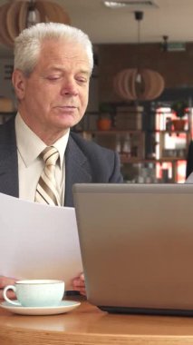 Şık bir kafede, özel dikim koyu takım elbiseli seçkin kıdemli bir işadamı ve zarif çizgili kravat önemli belgeleri incelerken, odaklanmış genç sakallı bir adam parlak dizüstü bilgisayarında özenle yazı yazıyor. Davetkar atmosfer, dumanı tüten bir atmosfer.