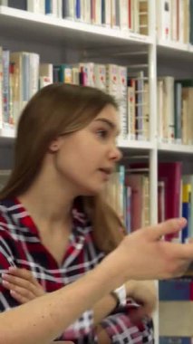 Renkli kitaplarla dolu canlı bir kütüphanede, yakışıklı sakallı bir adam dizüstü bilgisayarında ilginç ama kafası karışmış görünen güzel kahverengi saçlı bir kızla ateşli bir şekilde bir konuyu tartışırken hareketler yapıyor. Şiddetli değişimleri...